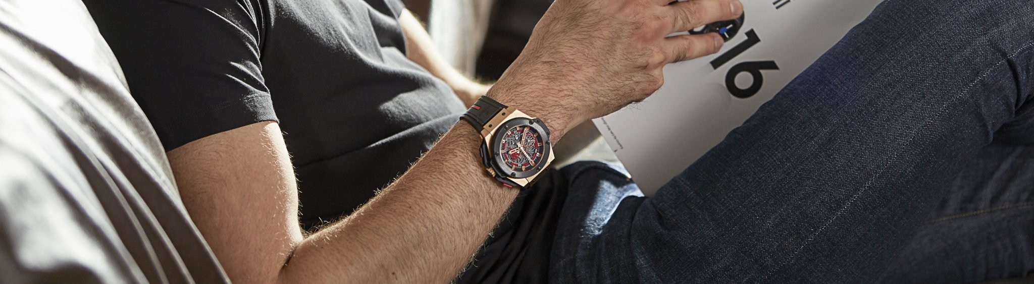 Man reading magazine wearing a Hublot Big Bang Watch