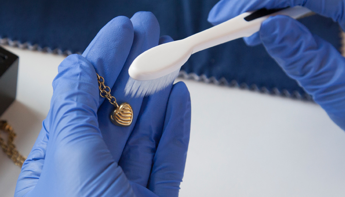 Cleaning a necklace with a toothbrush