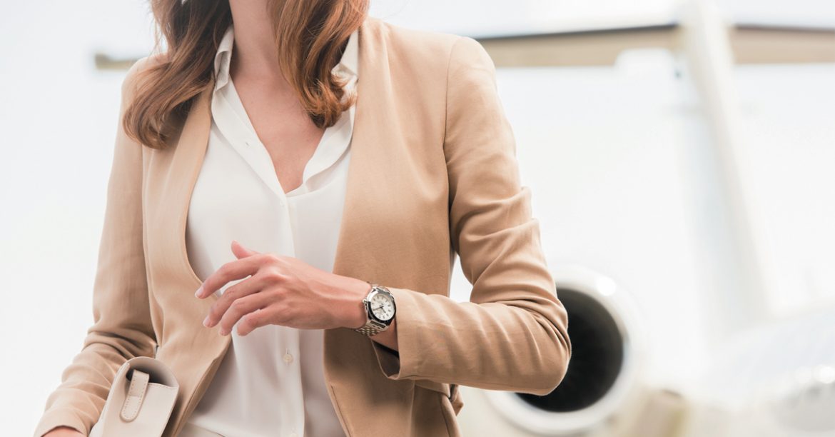 Woman wearing Breitling watch in front of plane