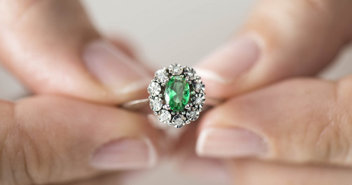Hands holding diamond. Emerald.