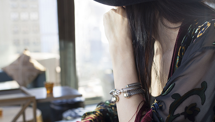 Woman wearing stack of David Yurman Cable Classic Cuffs.