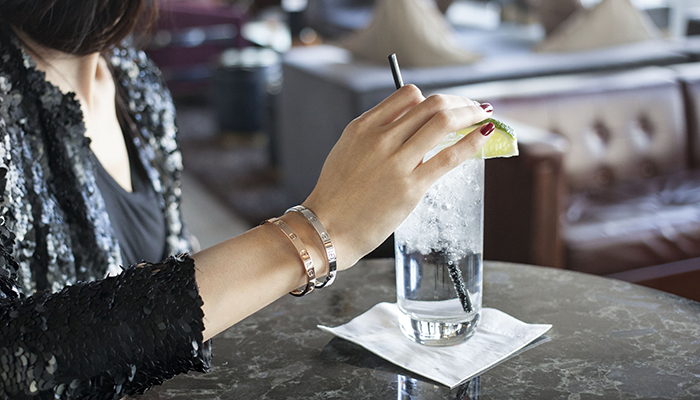 Woman wearing two Cartier Love Bracelets in yellow and white gold